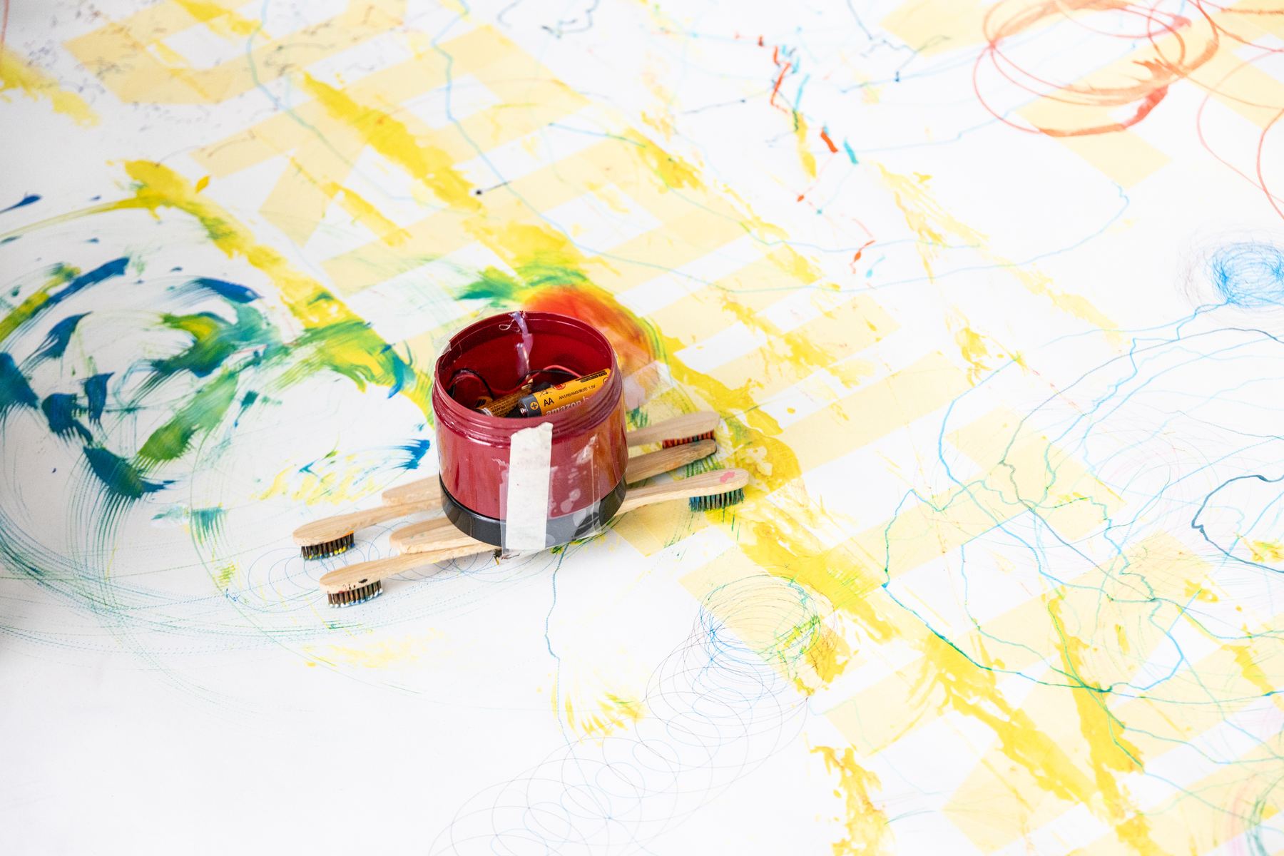 Robot 2 on the shared paper with yellow tape and green paint