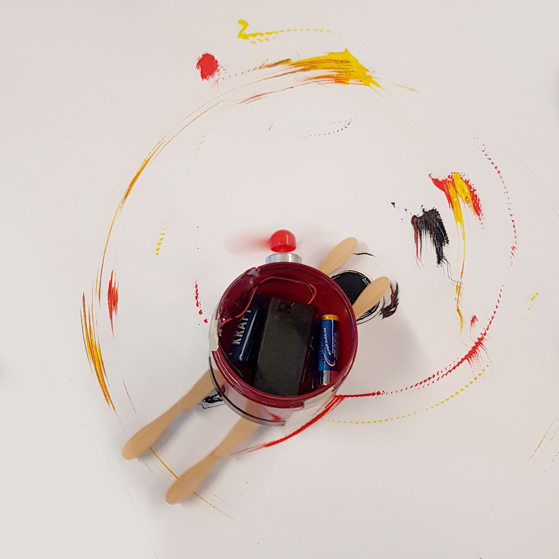 Robot 2 on paper with red, yellow and black circular strokes